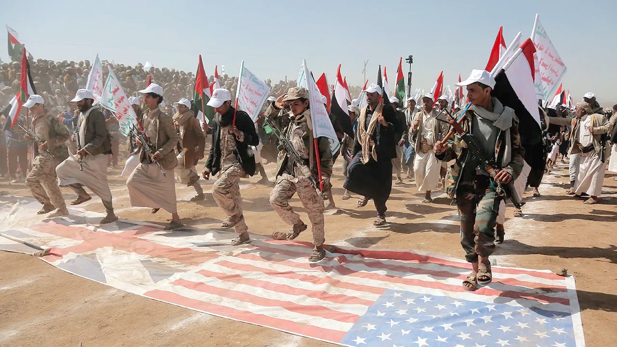 Houthi fighters trample, U.S., U.K. flags 