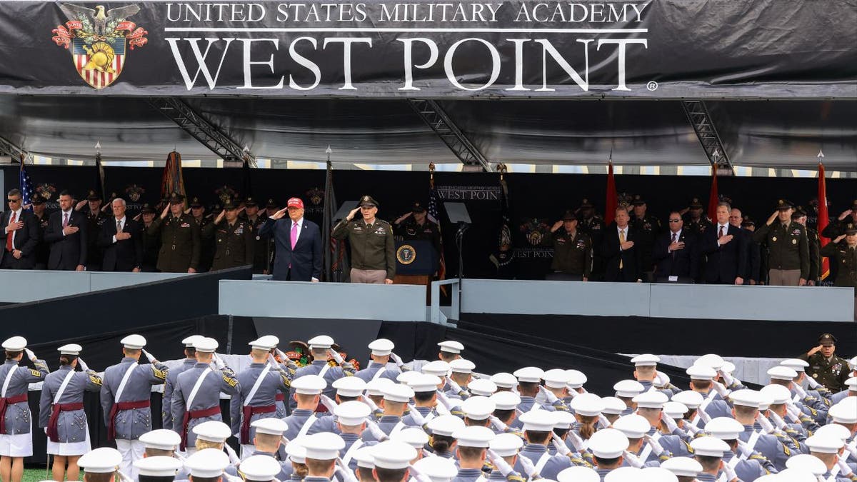 President Donald Trump and US Military Academy Superintendent Lt. Gen. Steven Gilland listen to the national anthem before Trump delivers the commencement address at the 2025 graduation ceremony at the US Military Academy West Point
