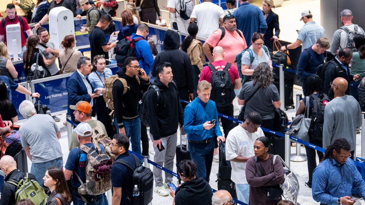 People wait in line at a security checkpoint at the George Bush Intercontinental Airport on November 6, 2025 in Houston, Texas. 