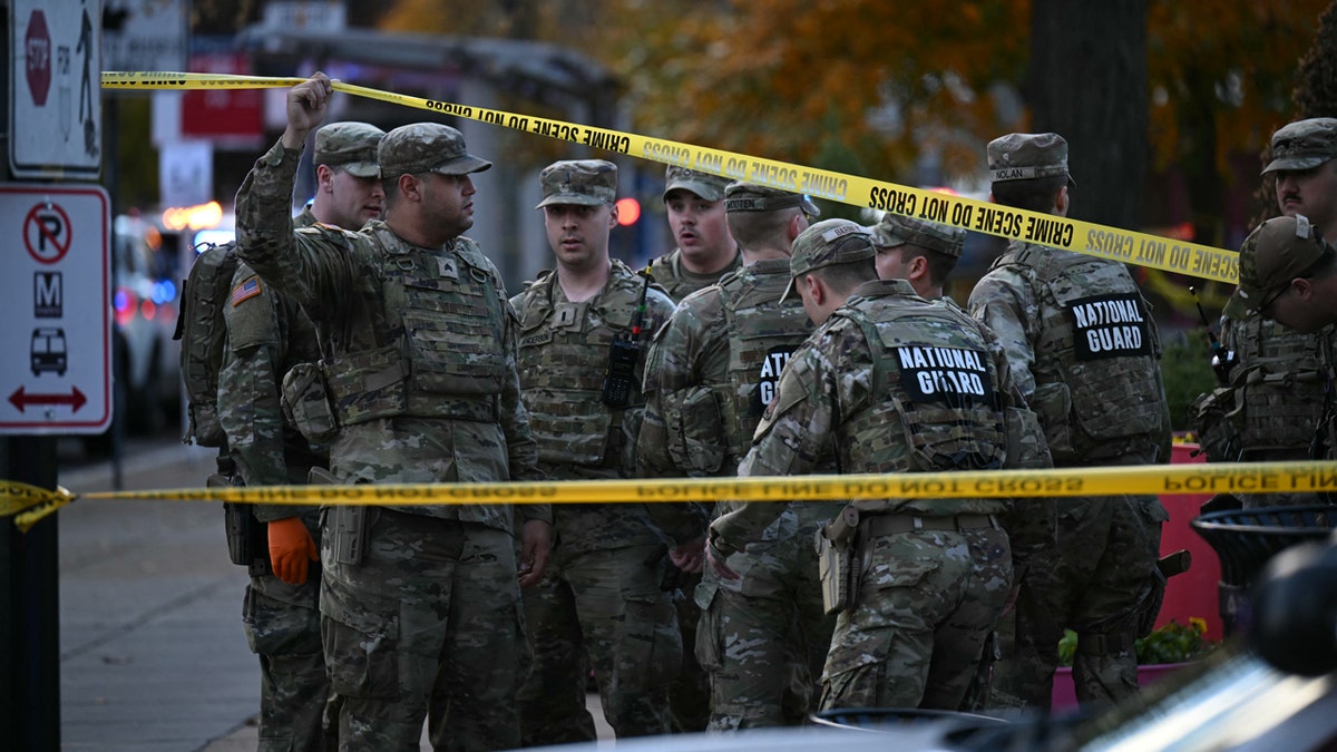 National Guard soldiers stand behind the crime scene tape at a corner in downtown Washington, Nov. 26, 2025. Two National Guard soldiers were shot a few blocks from the White House, according to law enforcement.