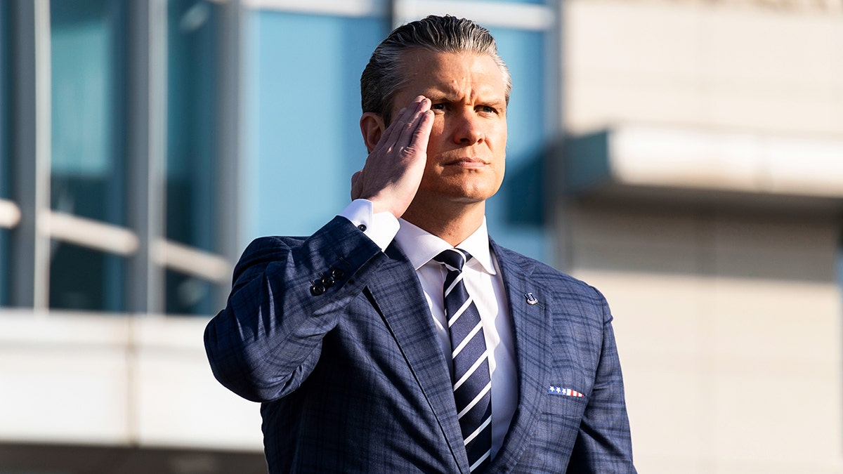 The Secretary of War, Pete Hegseth, giving a salute.