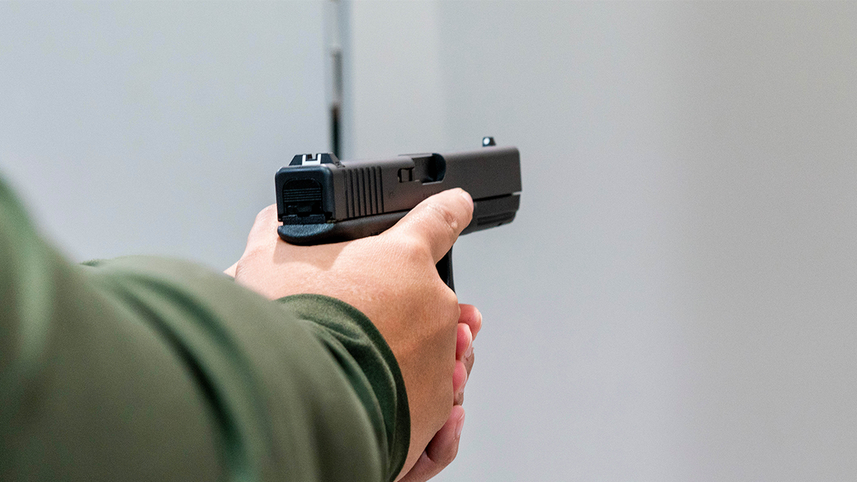 Man holds firearm.