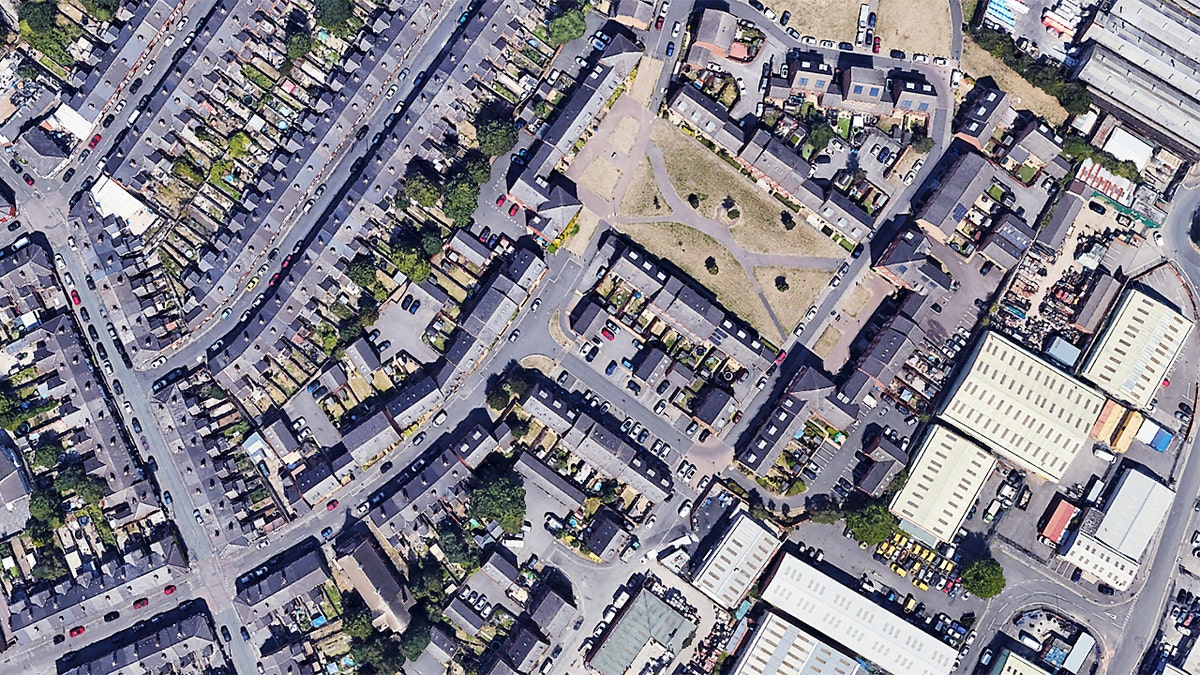 Aerial view of residential streets and an open green space in Derby with cars parked along multiple roads.