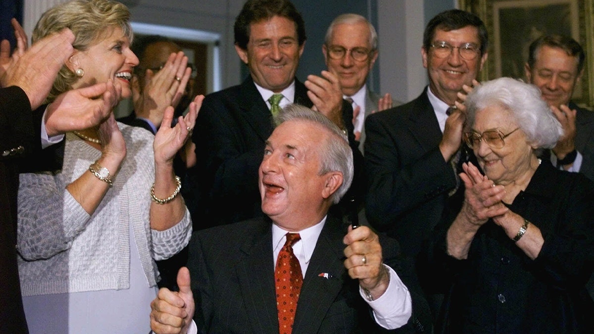 Jim Hunt smiles after signing orders in front of office