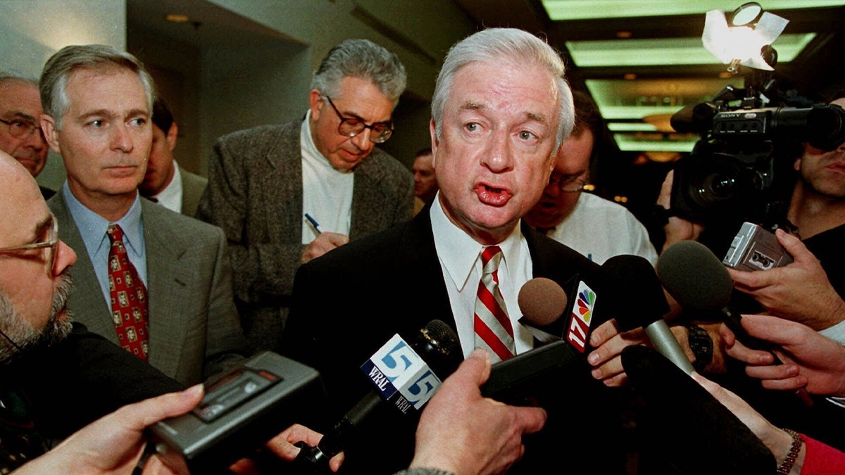 Jim hunt speak to reporters holding microphones