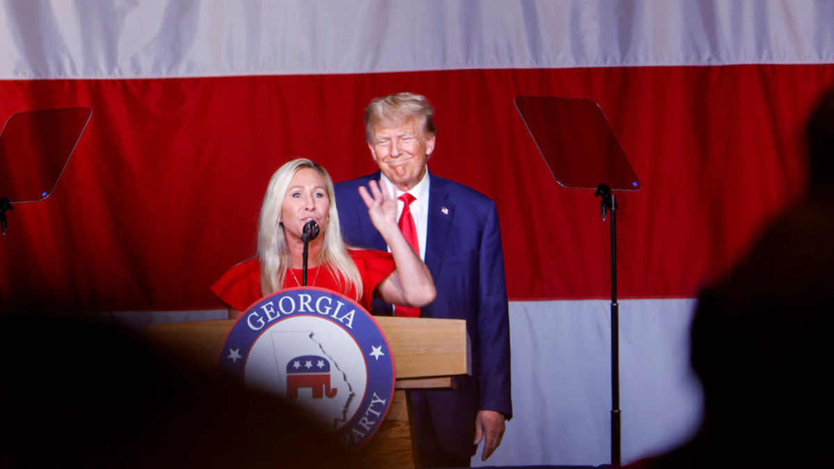 Marjorie Taylor Greene and Donald Trump on stage together.