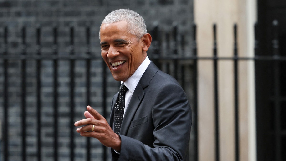 Former President Obama smiles at the media 