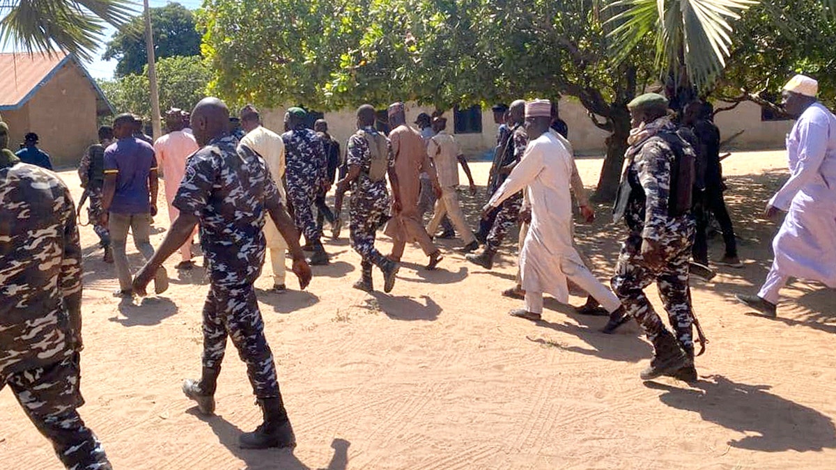 Police and government officials walking in daytime on school grounds