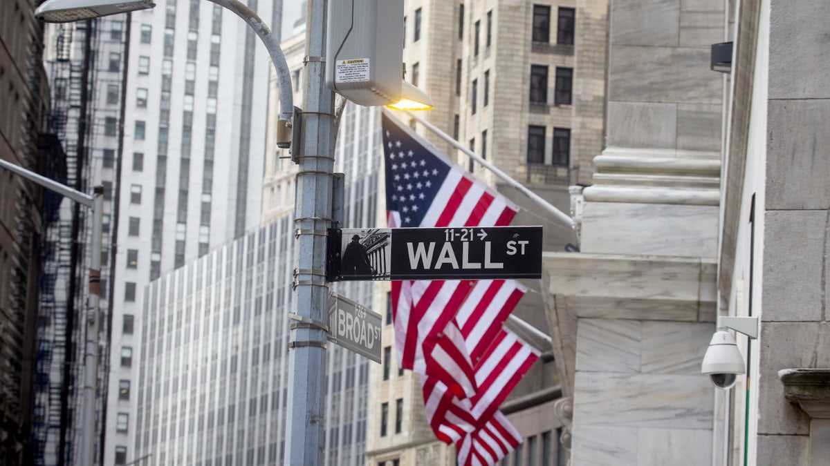 American flags behind Wall Street sign in New York City