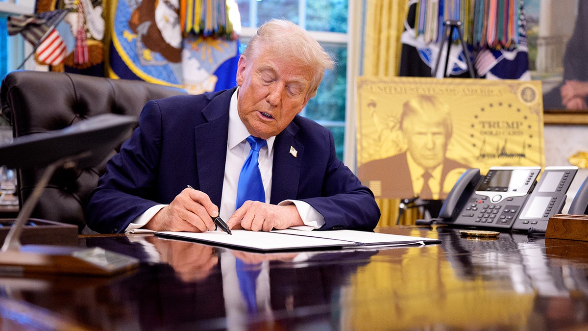President Donald Trump sits in Oval Office and signs executive orders