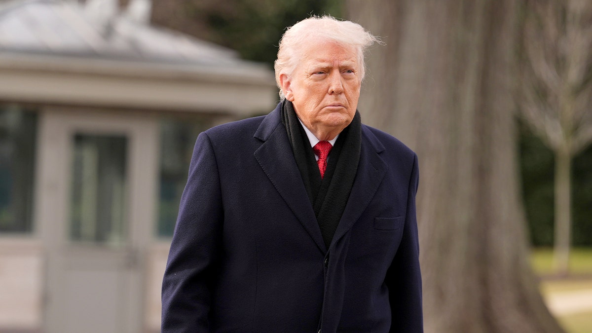 president trump walks across the White House lawn toward a helicopter for departure.