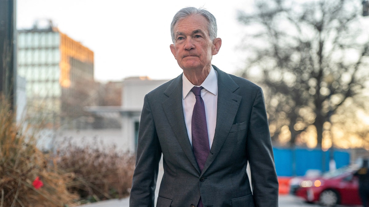 Central bank chief walks toward the headquarters building ahead of scheduled meetings.