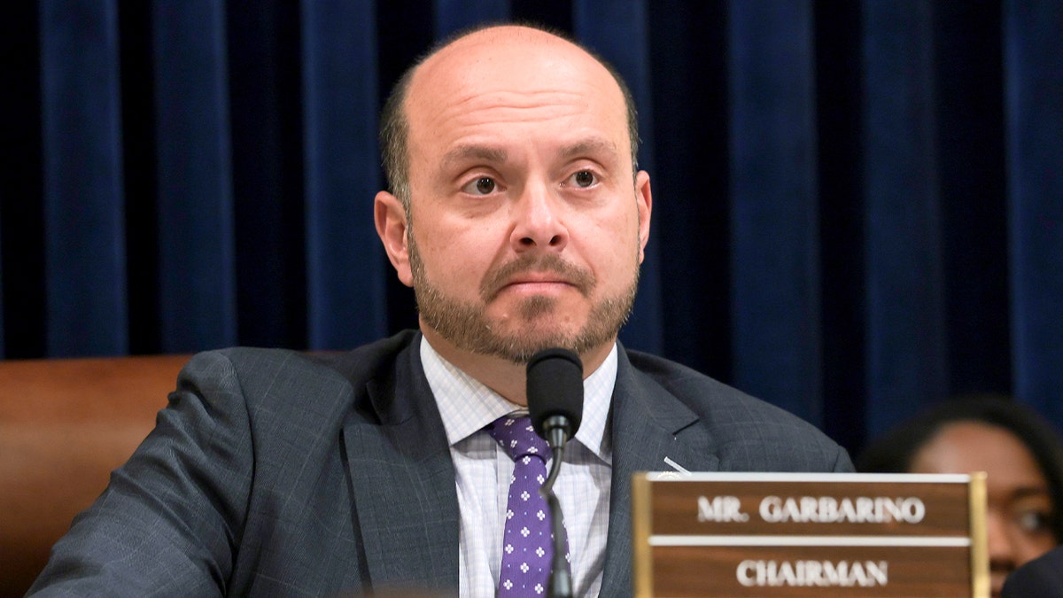 A lawmaker sits during a formal congressional hearing inside a government building.