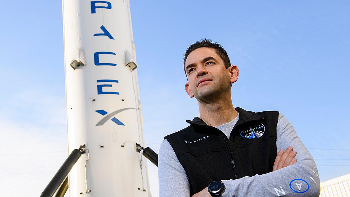 NASA Administrator Jared Isaacman in front of a SpaceX rocket.
