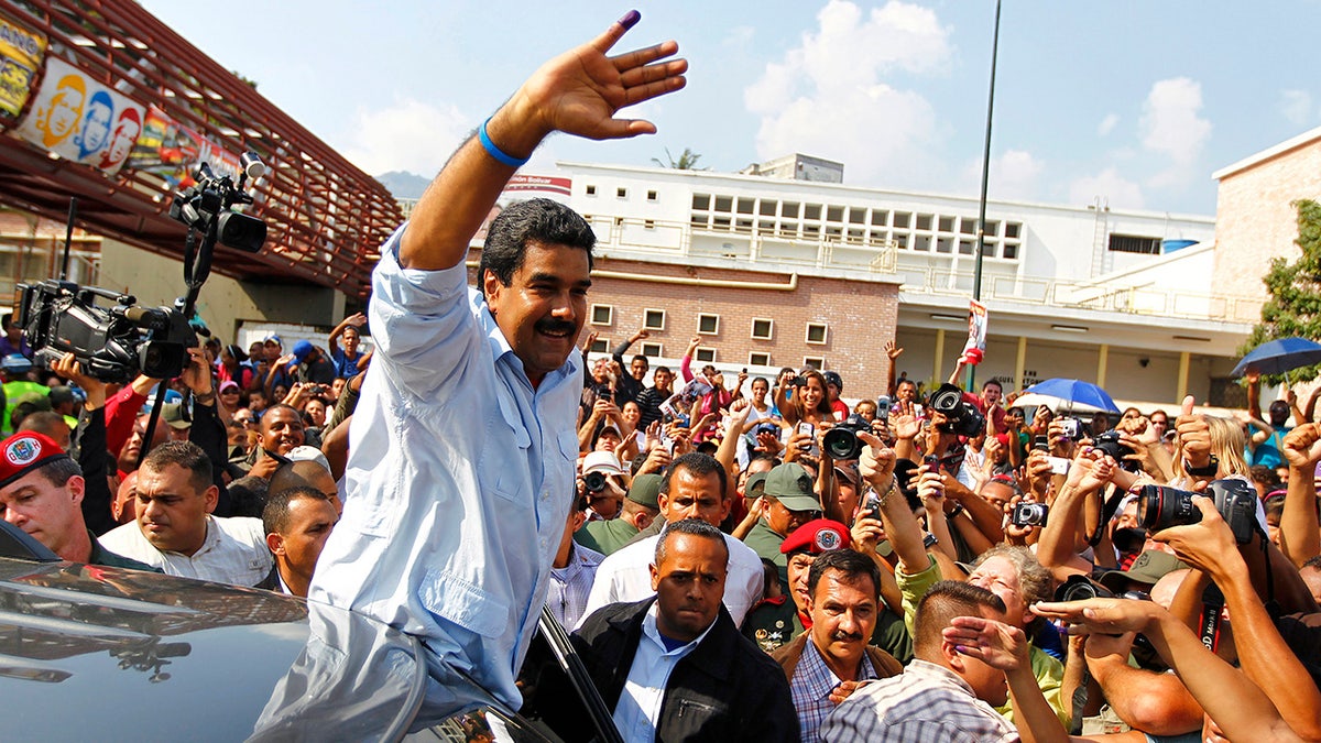 Venezuelan President Nicolas Maduro waves in front of crowd of supporters