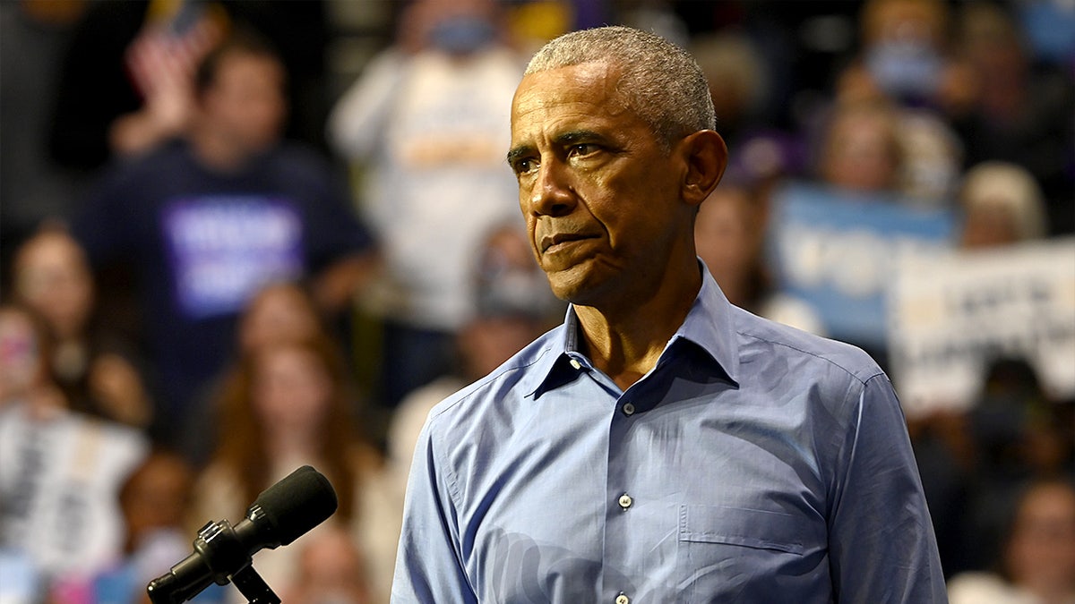 Former President Barack Obama speaks during a rally inside a college gymnasium.