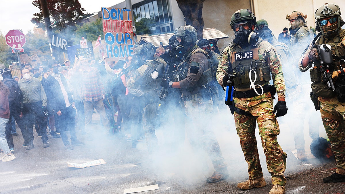 Federal agents in tactical gear clash with protesters outside a U.S. Immigration and Customs Enforcement facility.