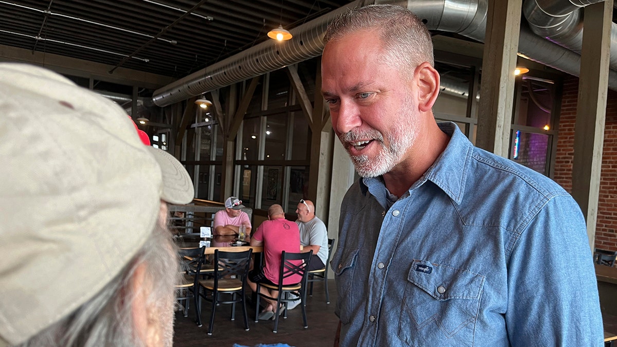 Independent Dan Osborn chats with guests at a brewery in Beatrice, Neb., on July 30.