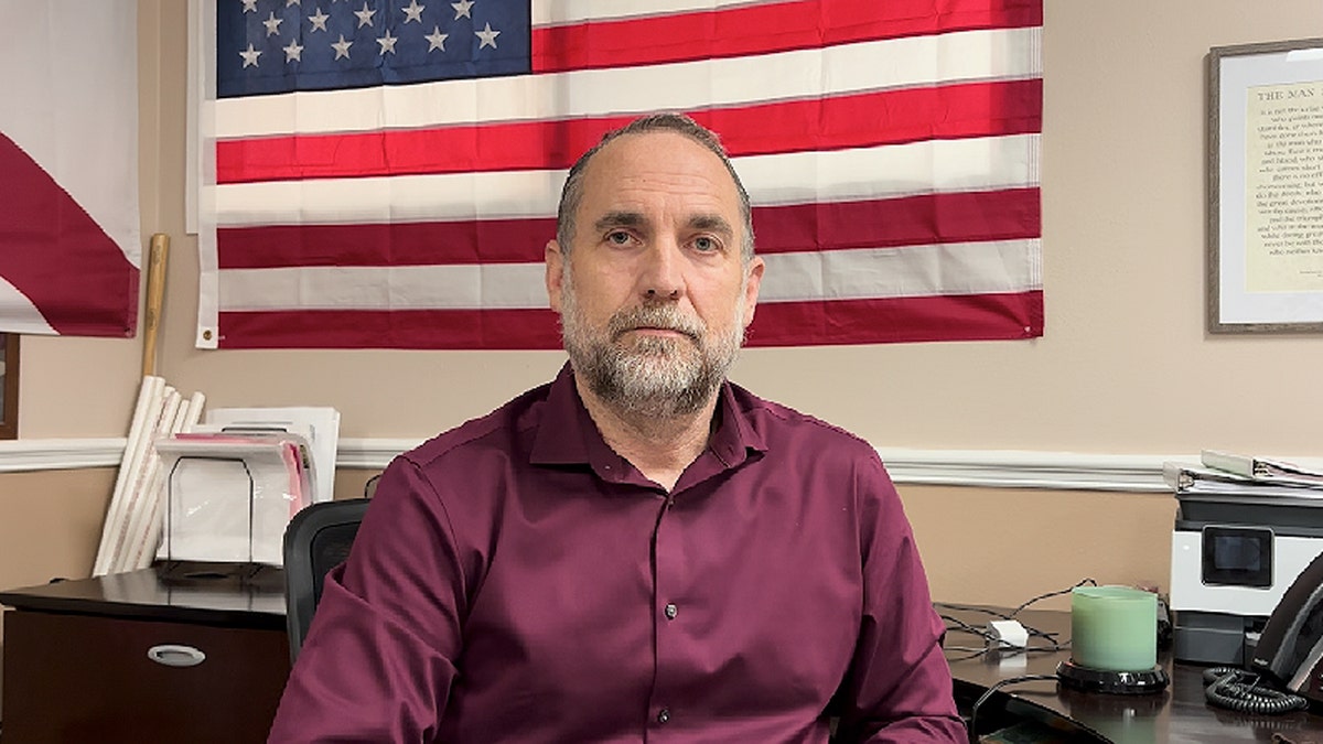 Eddie Speir sitting in front of an American flag