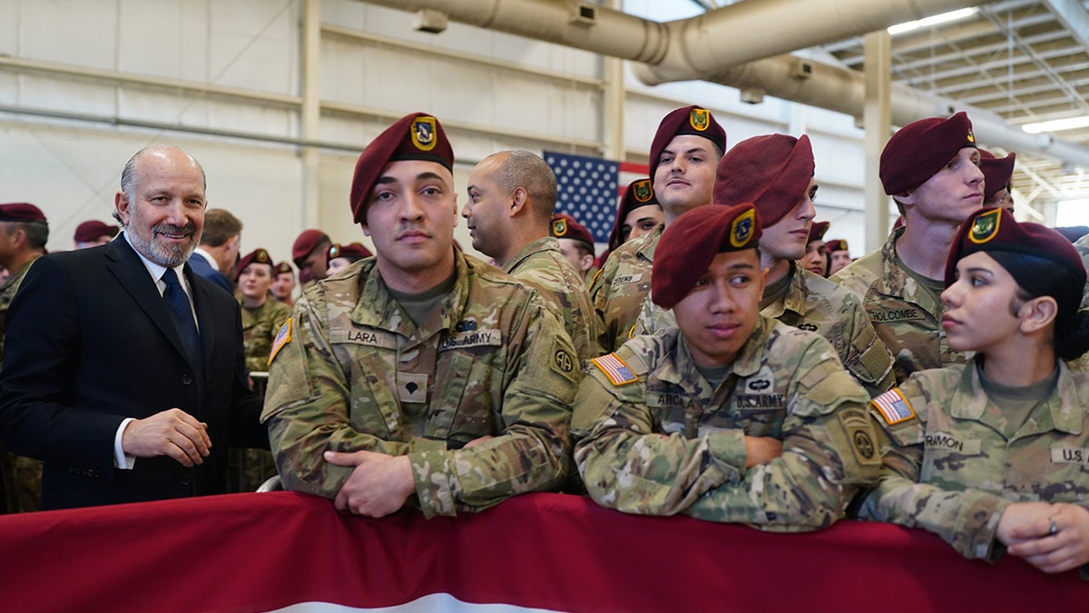 Secretary of Commerce Howard Lutnick, left, waits for President Donald Trump to speak during a visit to the Army base in Fort Bragg, North Carolina, Feb. 13, 2026. 