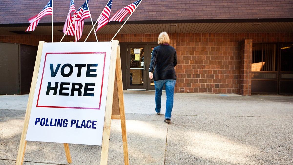 Photo shows woman walking into voting station