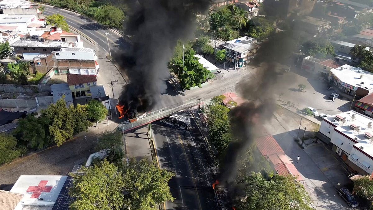 Smoke billows from burning vehicles amid a wave of violence, with torched vehicles and gunmen blocking highways in more than half a dozen states, following a military operation in which a government source said Mexican drug lord Nemesio Oseguera, known as "El Mencho," was killed, in Puerto Vallarta, Jalisco, Mexico, Feb. 22, 2026.