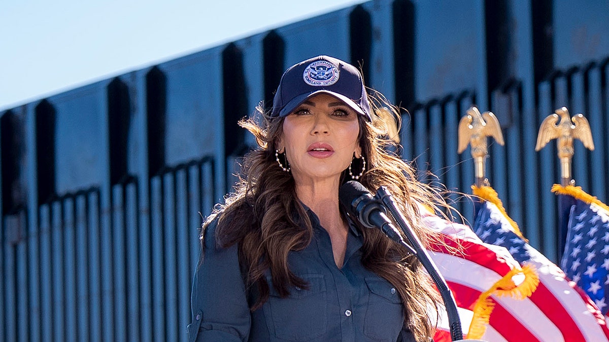 DHS Sec. Kristi Noem speaking in front of the border wall.