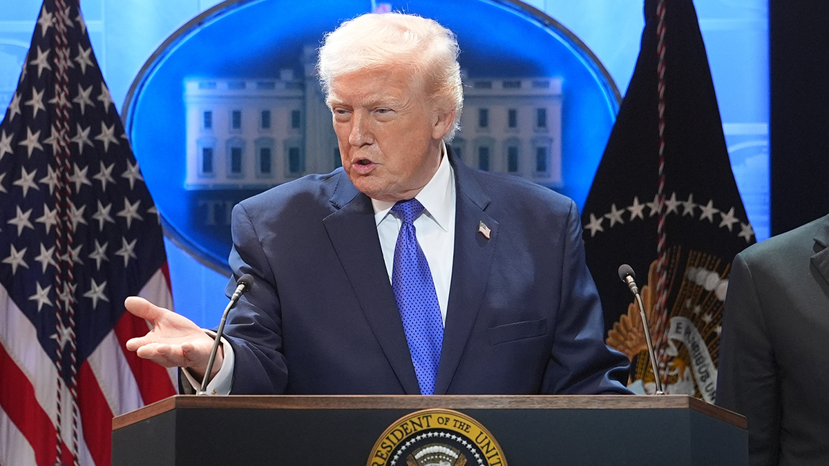 President Donald Trump speaks during a press briefing at the White House, Friday, Feb. 20, 2026, in Washington, as Commerce Secretary Howard Lutnik, looks on.