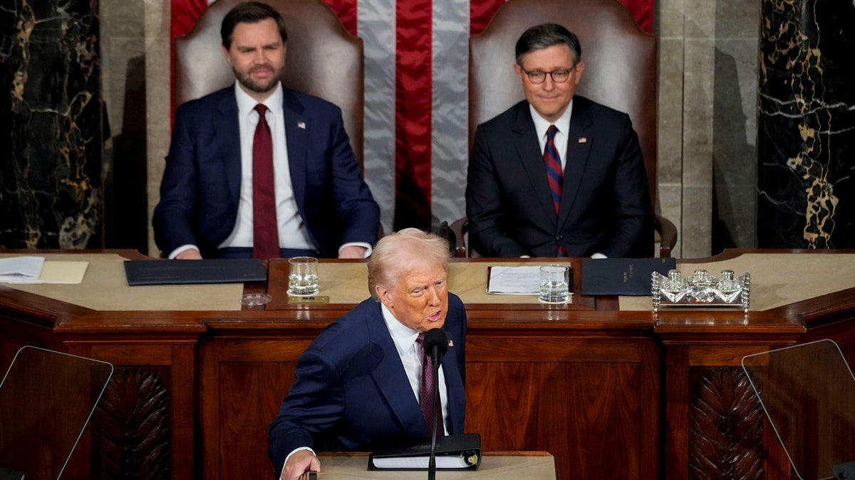 Donald Trump delivers a joint address to Congress as Vice President JD Vance and Speaker Mike Johnson look on.