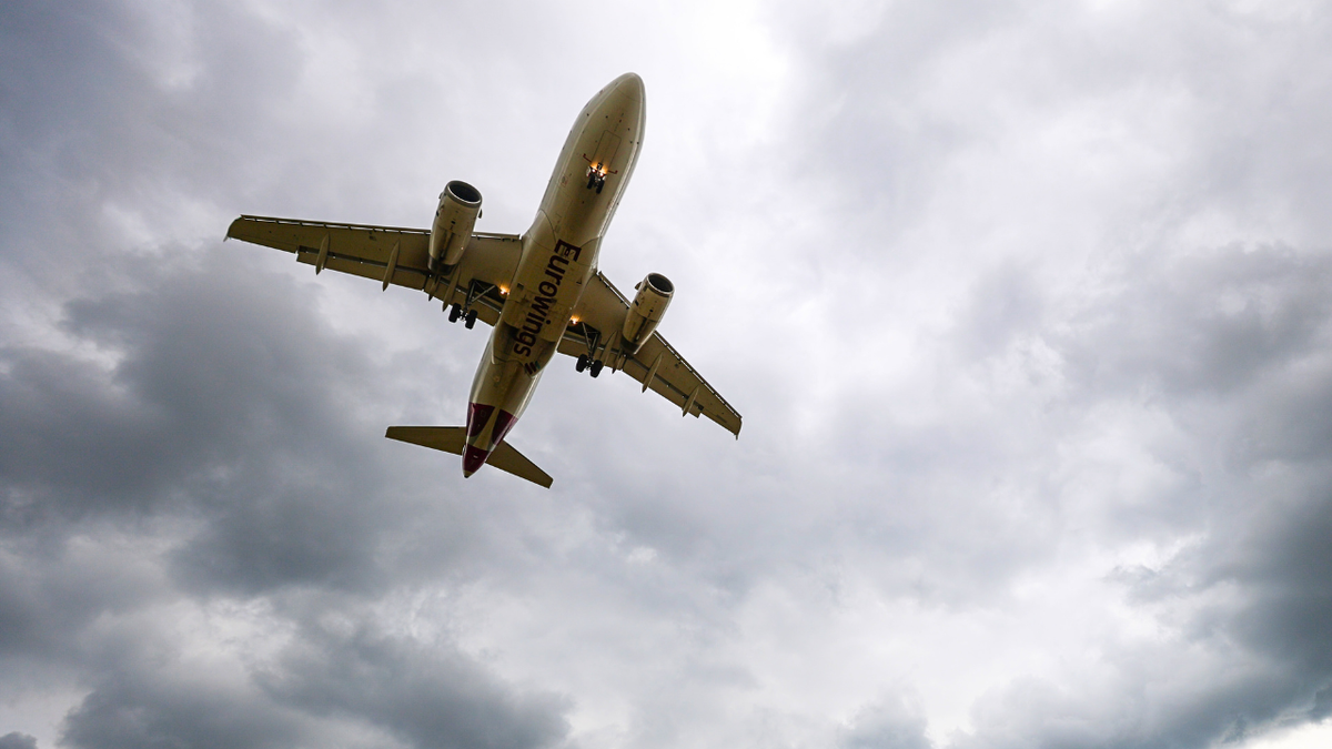 An Airbus A320 is seen flying through cloudy skies.