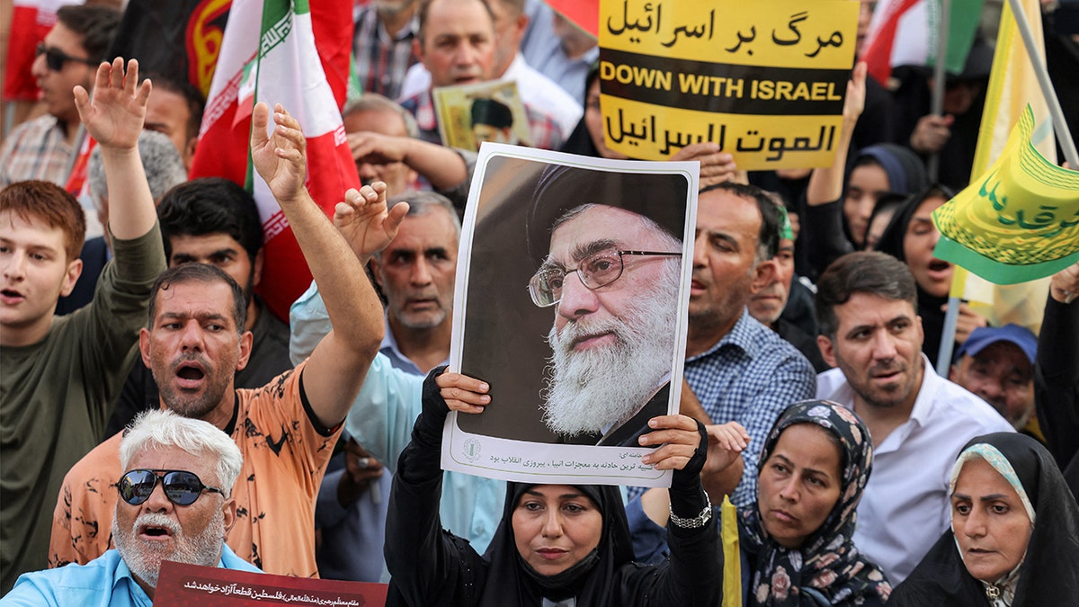 A demonstrator holding a picture of Ayatollah Ali Khamenei during a rally in Tehran