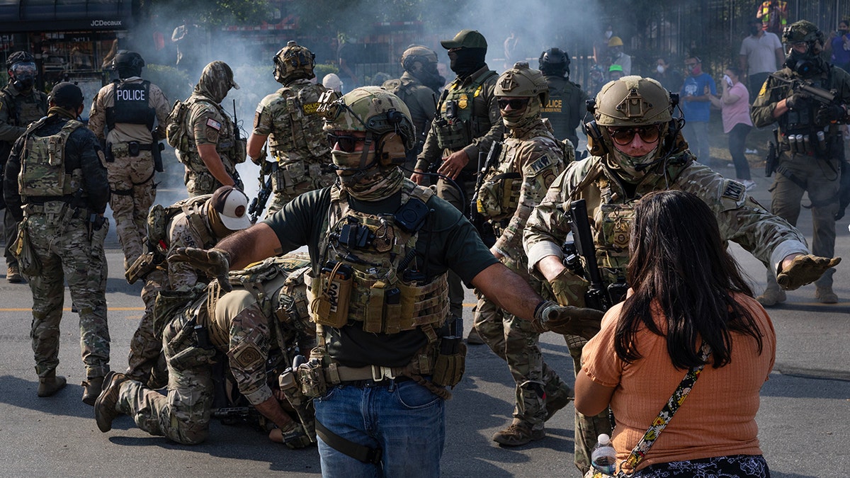 federal agents in camouflage uniforms clash with Broadview anti-ICE protestors