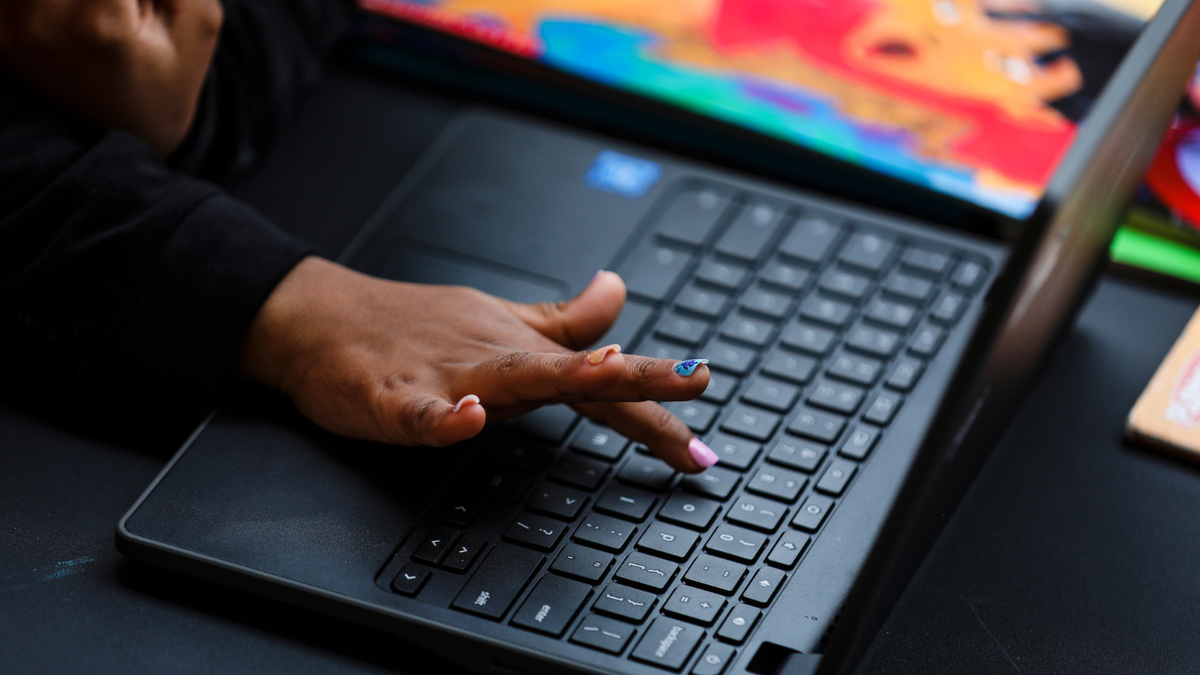 A child learns how to find a letter on a keyboard on a computer in Boston on April 8, 2021. (Erin Clark/The Boston Globe via Getty Images)