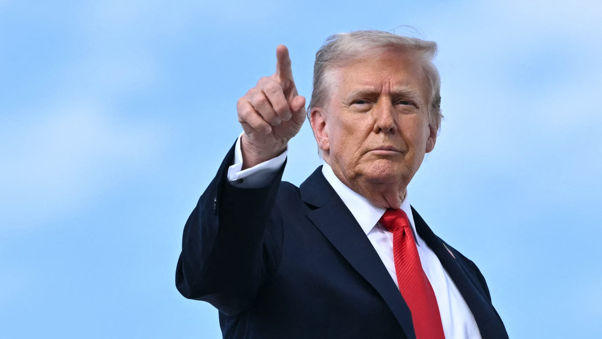 U.S. President Donald Trump points at cameras before boarding Air Force One