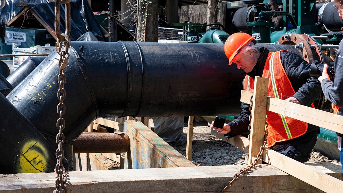 Worker fixing Potomac pipes after spill