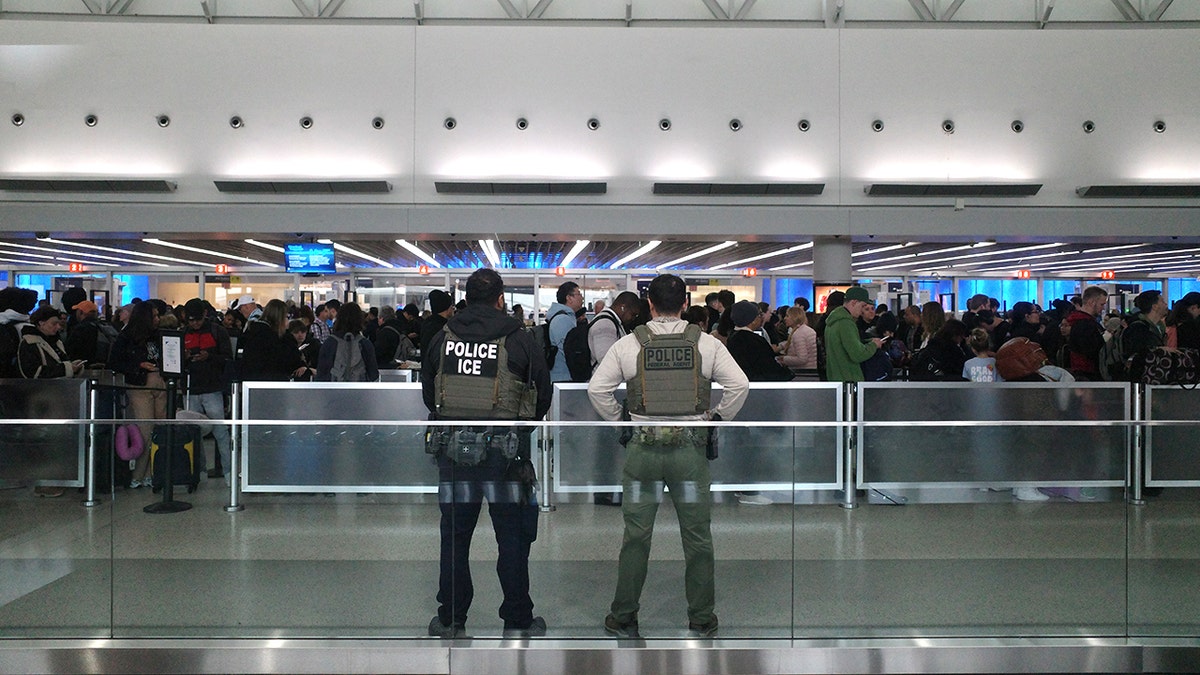 ICE agents walking through a terminal at JFK Airport.