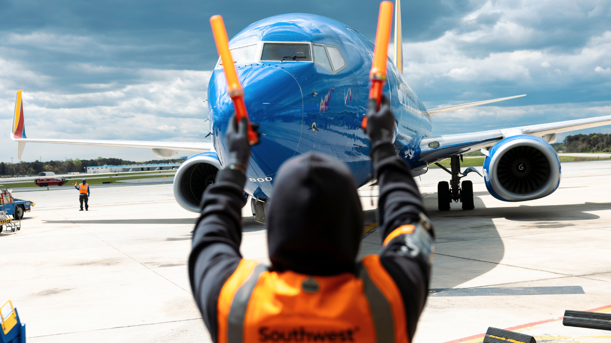 A plane is seen being directed by a ramp agent at a gate at Baltimore-Washington airport.