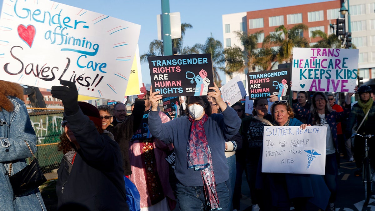 Members of Rainbow Families holding a banner and marching down a city street.