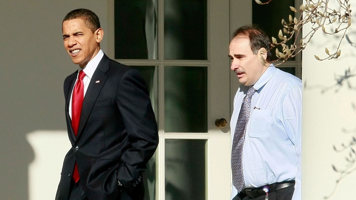 Barack Obama and David Axelrod seated and talking at an event