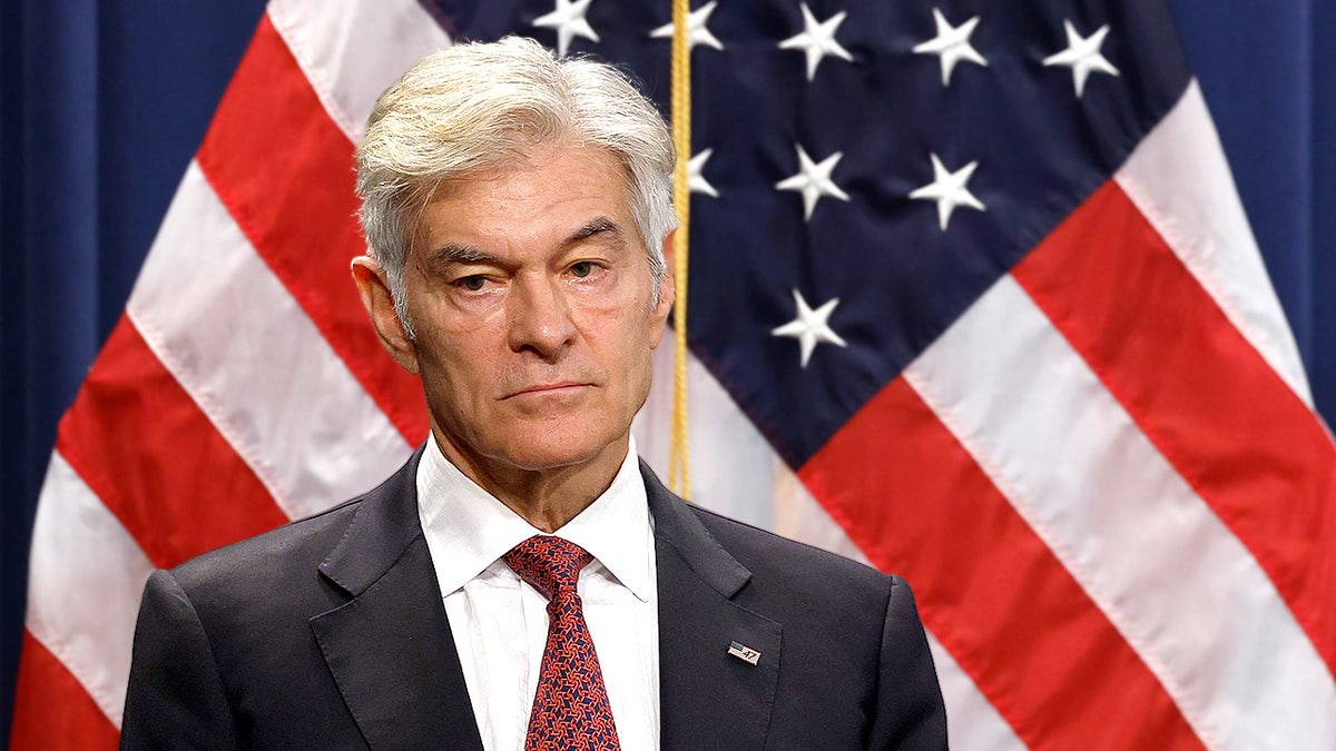 CMS Administrator Mehmet Oz speaking at a Department of Justice press conference with an American flag behind him