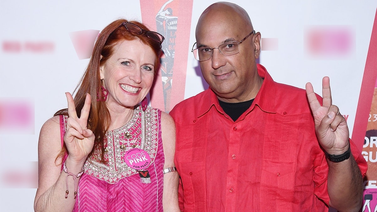 Jodie Evans and Neville Roy Singham standing together at an event