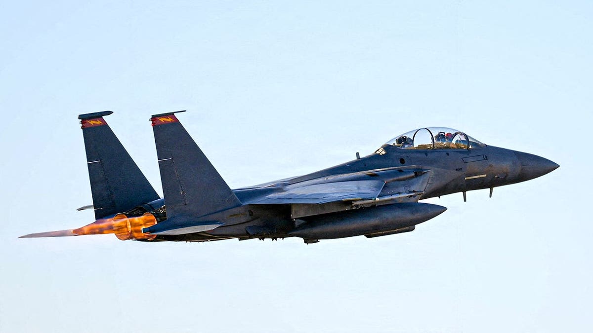 An F-15E Strike Eagle jet taking off from a runway.