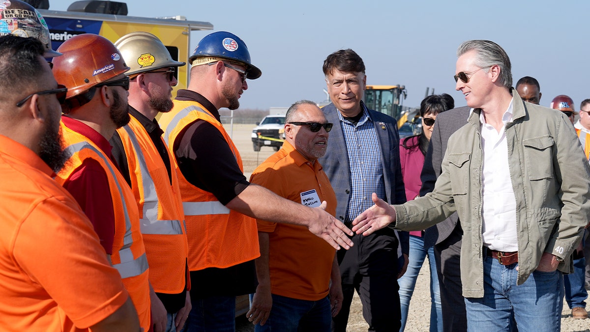 California Gov. Gavin Newsom and California High-Speed Rail Authority CEO Ian Choudri shaking hands with Iron Workers Local 155 members at a railhead site