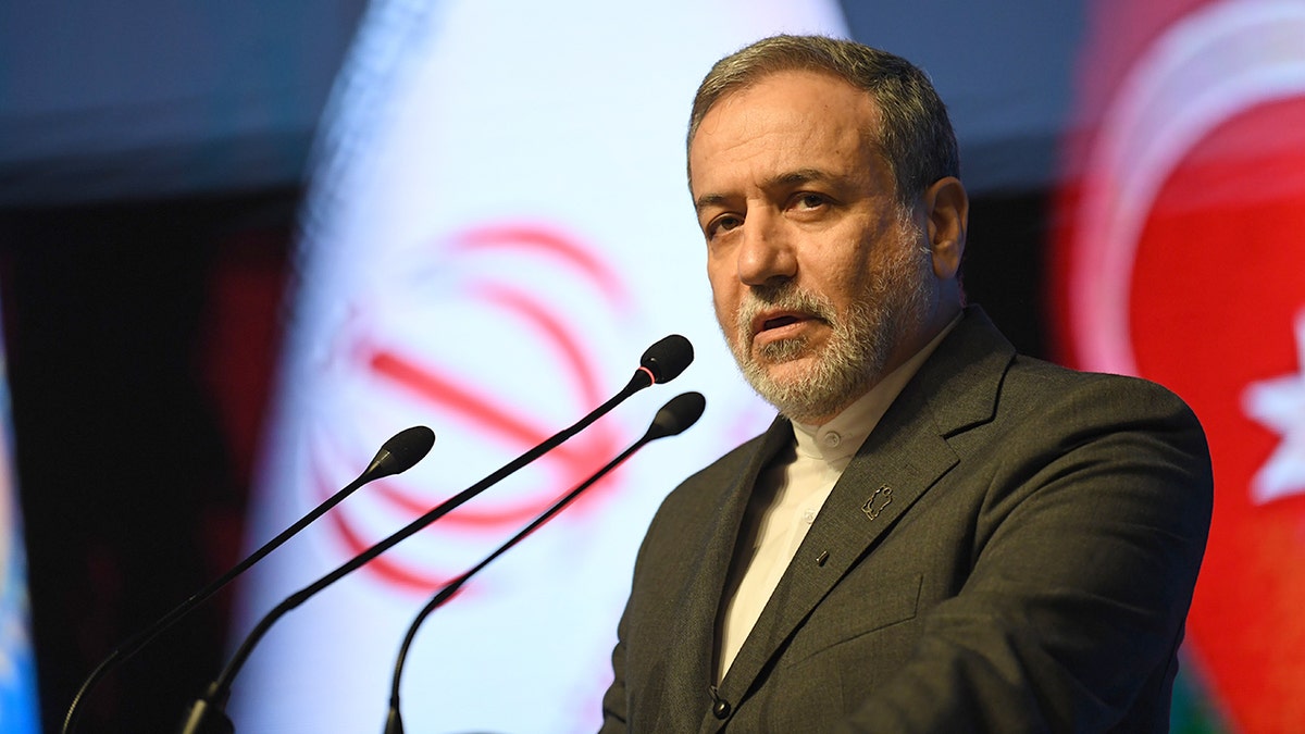 Iranian Foreign Minister Seyed Abbas Araghchi speaking at a podium during an event in Rasht, Iran