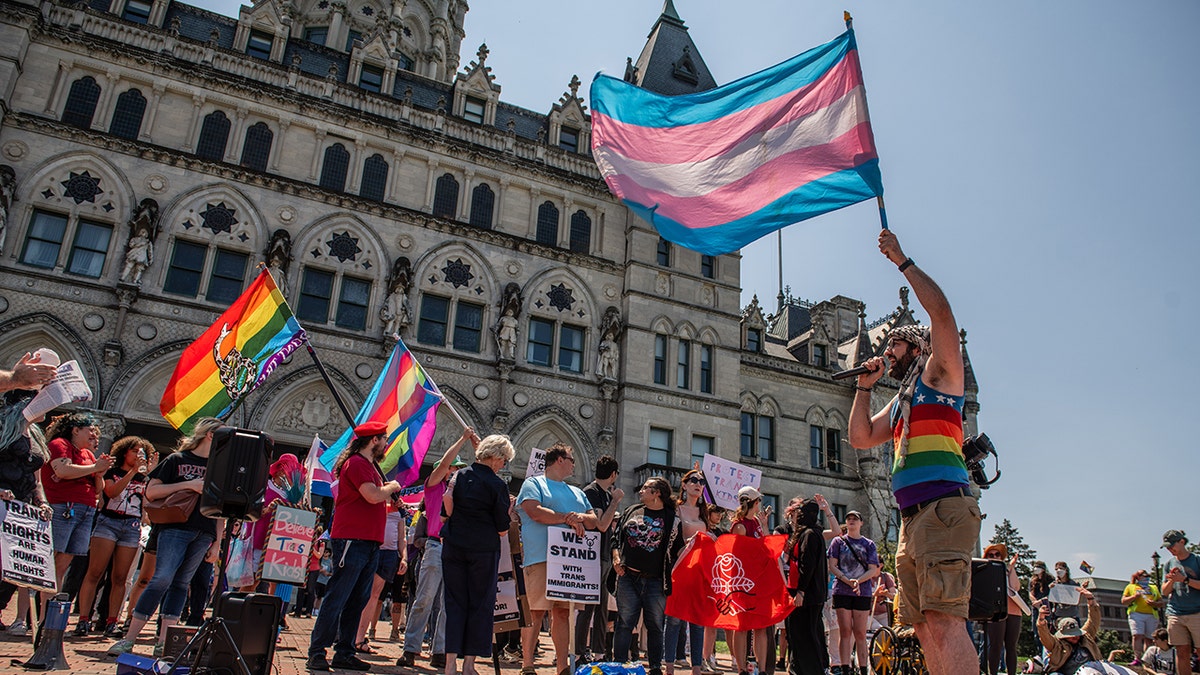 LGBTQ community members holding flags and placards at a rally in Hartford, Conn.