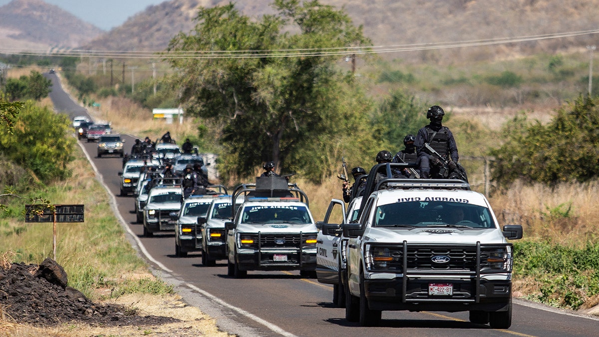  Members of the Civil Guard of Michoacan patrol a highway supported by armored vehicles after a wave of violence in the town of Aguililla, the birthplace of drug kingpin Nemesio Oseguera, leader of the Jalisco New Generation Cartel (CJNG) in Tierra Caliente, Mexico, on February 24, 2026. 