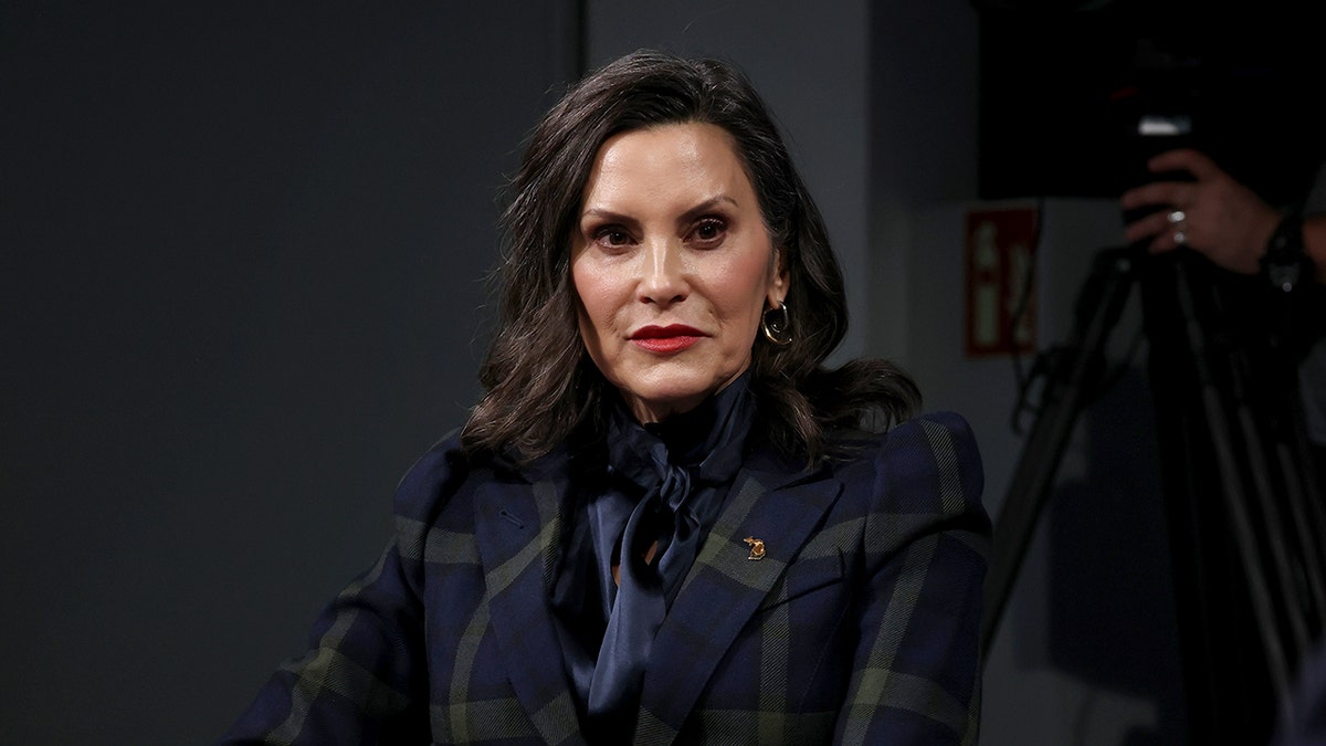 Michigan Governor Gretchen Whitmer listening to Rep. Alexandria Ocasio-Cortez speaking at a townhall panel