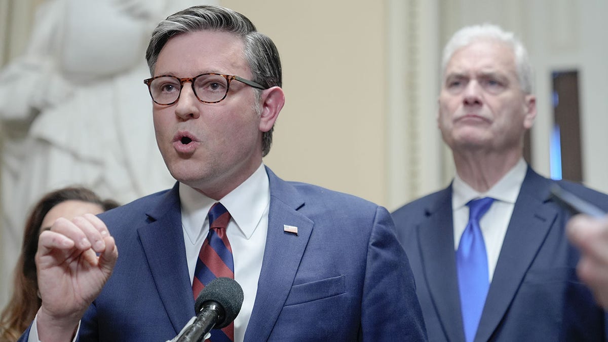 House Speaker Mike Johnson speaking during a news conference with House Majority Whip Tom Emmer listening