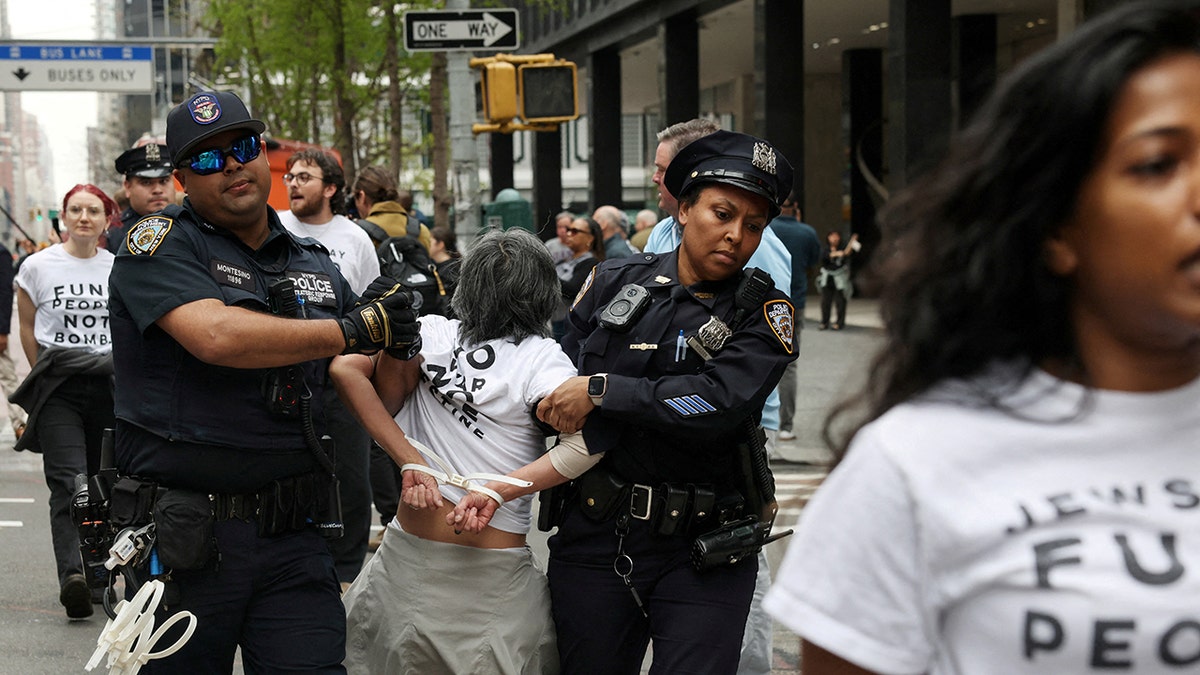 NYPD officers detaining a demonstrator on a city street in New York City