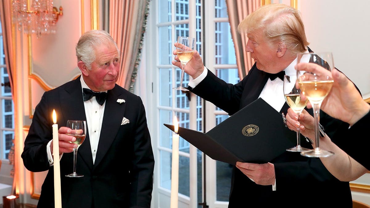 President Donald Trump and Prince Charles standing and toasting at a dinner event in London